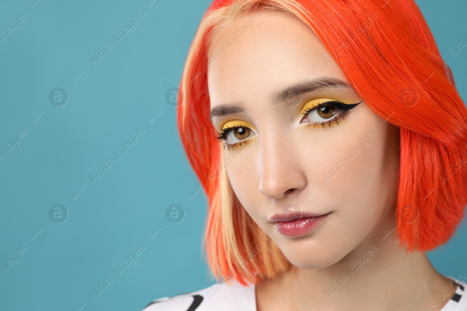 Photo of Beautiful young woman with bright dyed hair on turquoise background, closeup. Space for text