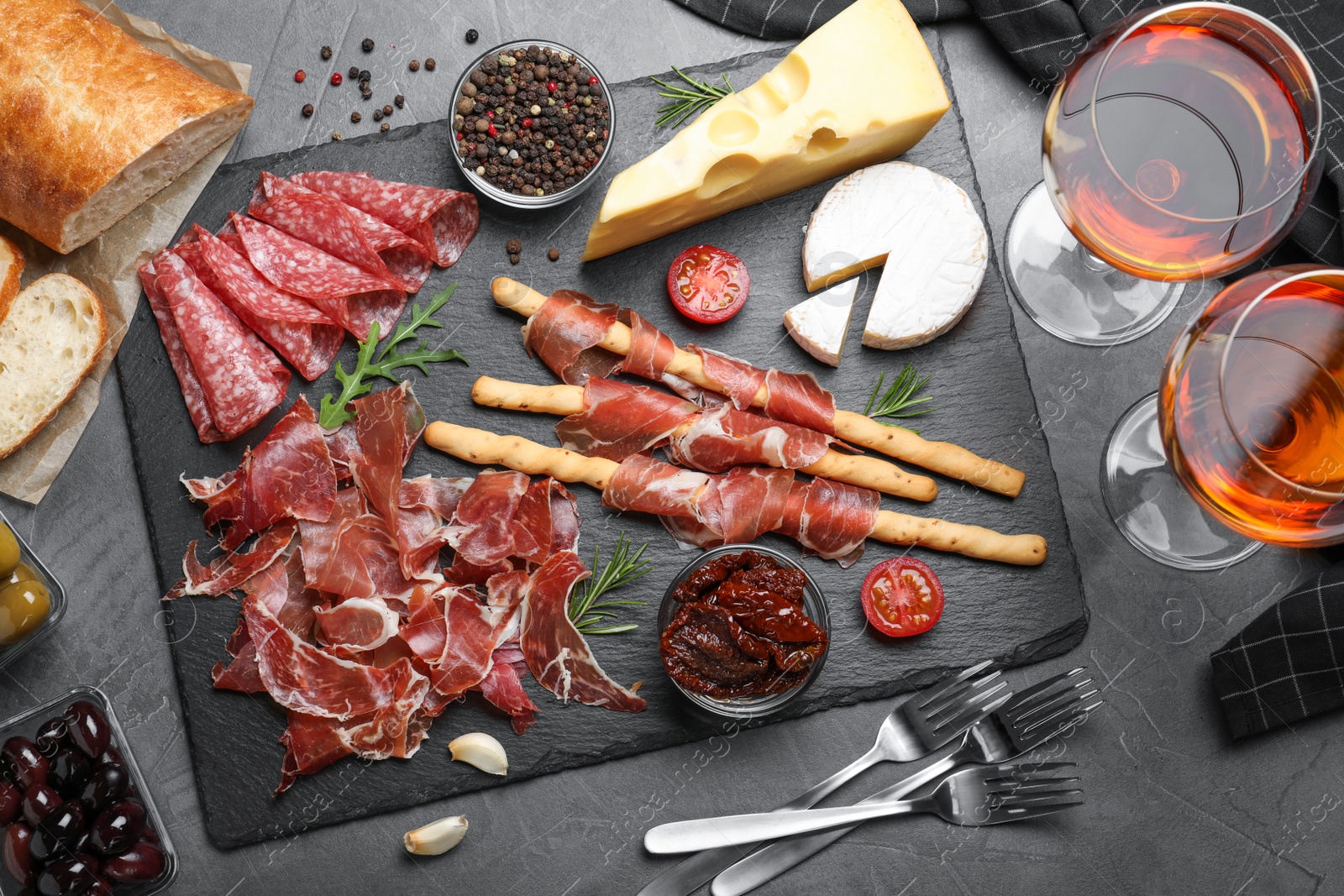 Photo of Tasty prosciutto served on grey table, flat lay