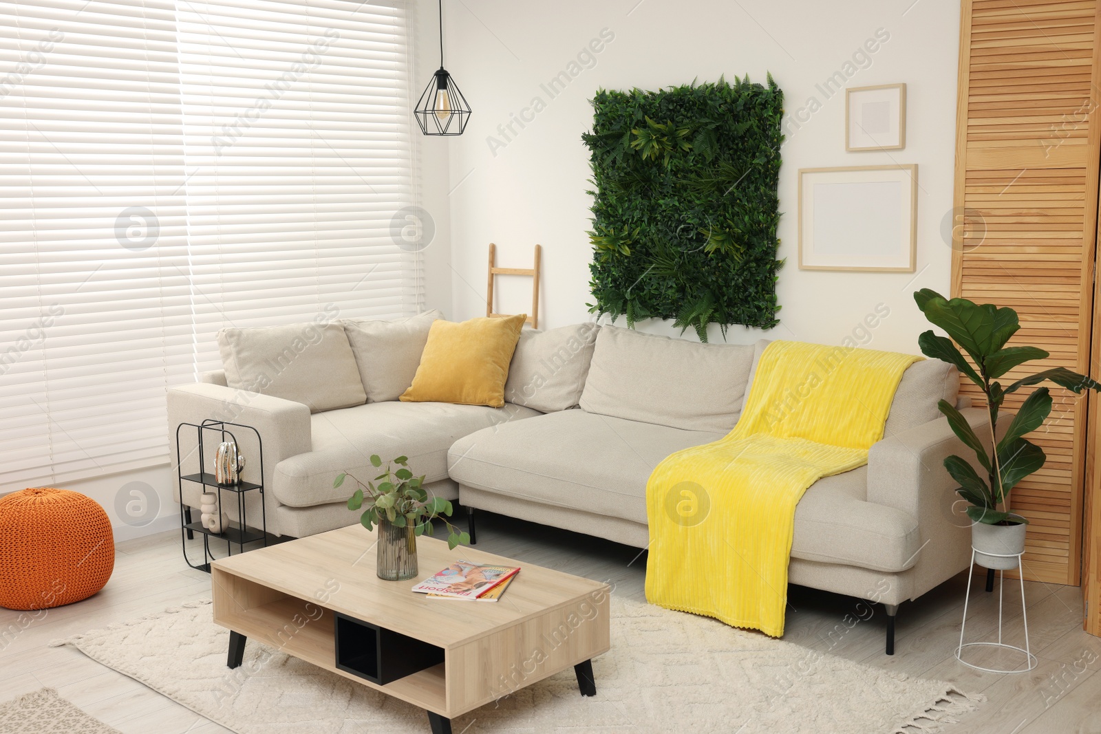 Photo of Green artificial plant wall panel and comfortable furniture in cozy living room. Interior design