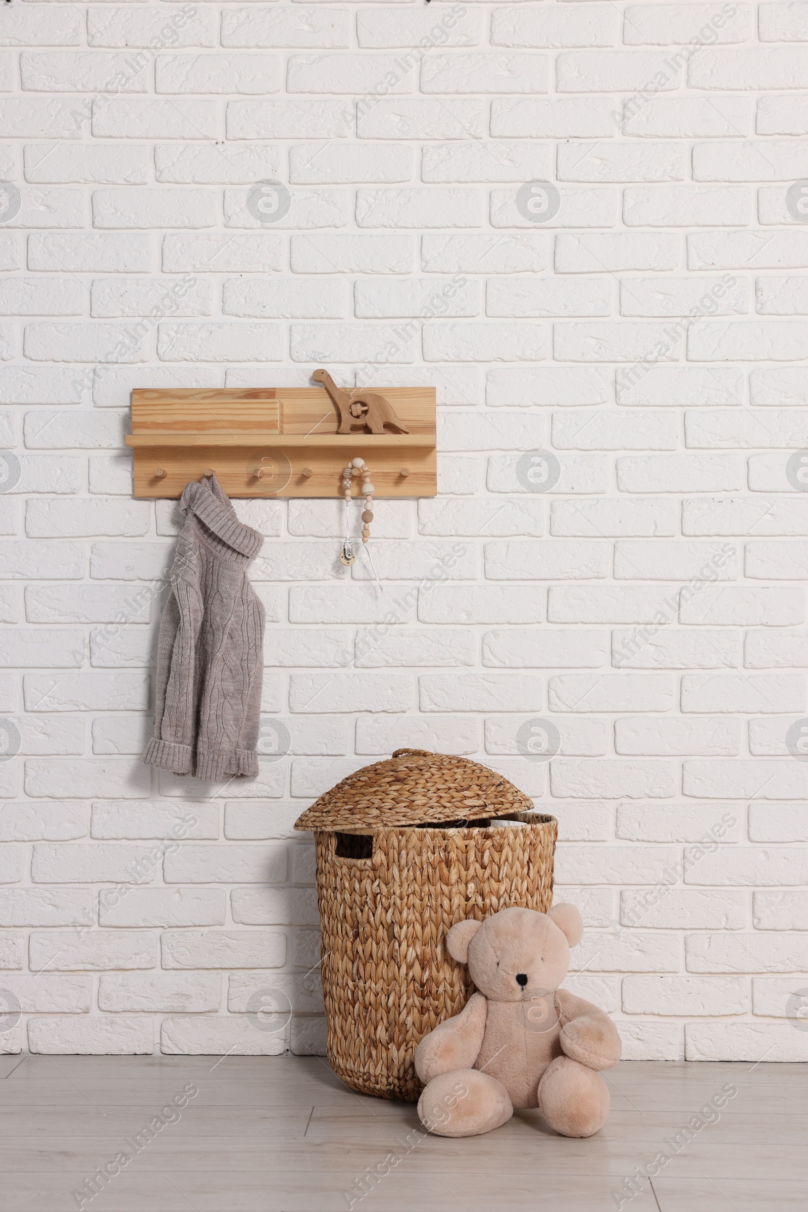 Photo of Beautiful children's room with white brick wall and toys. Interior design