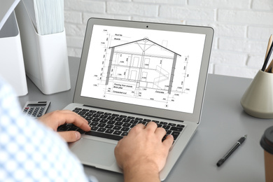 Image of Architect making project of house on laptop in office, closeup