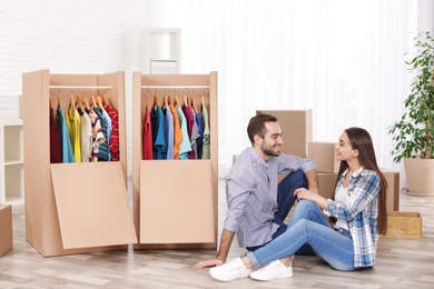 Young couple near wardrobe boxes at home