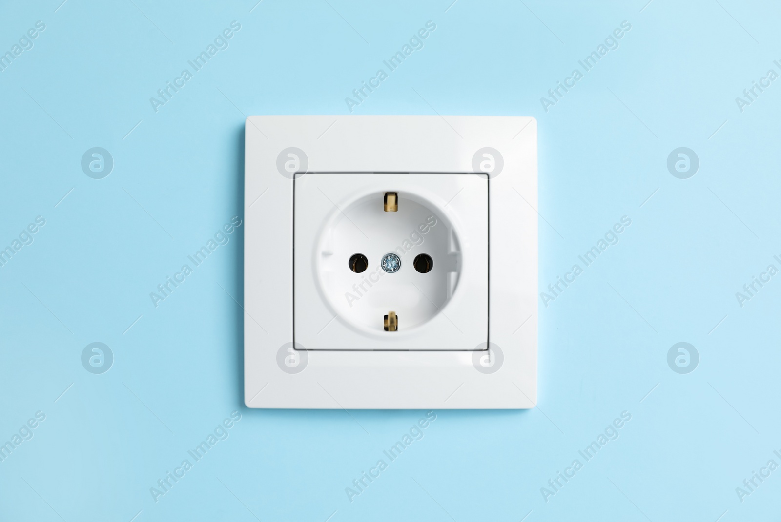 Photo of Power socket on light blue wall. Electrical supply