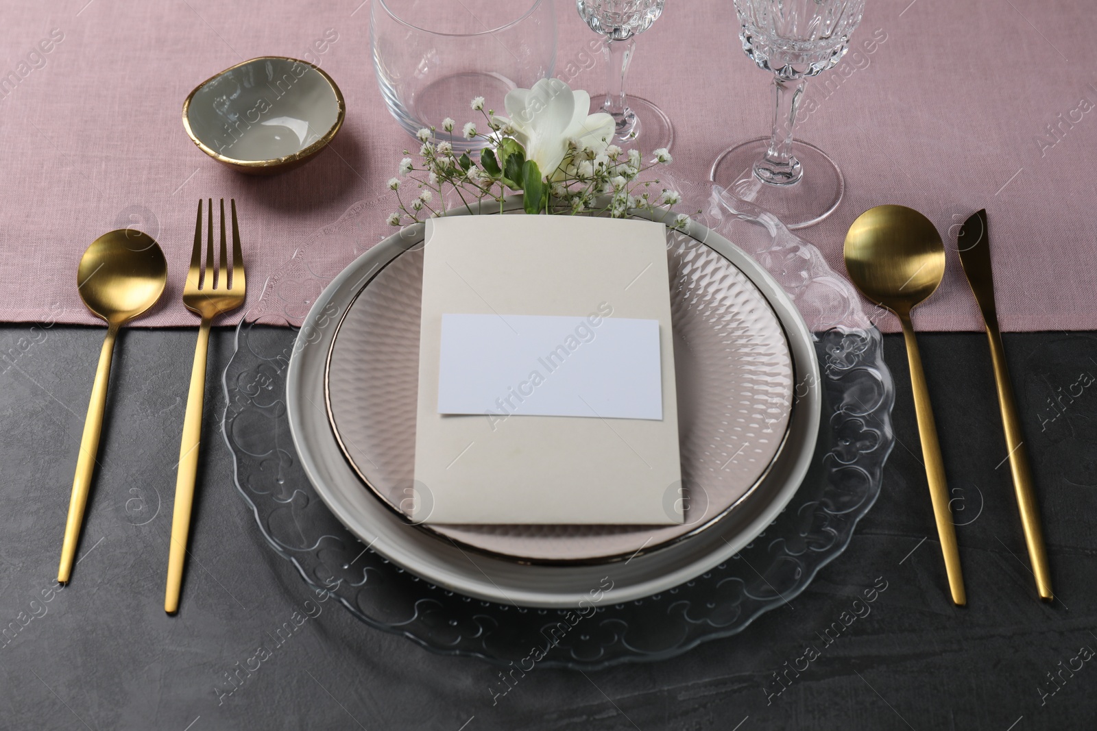 Photo of Stylish table setting. Dishes, cutlery, blank card and floral decor
