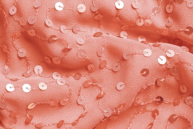 Photo of Beautiful red cloth with sequins as background, closeup