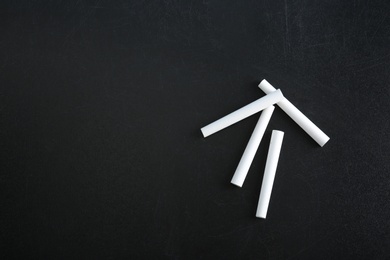 Pieces of chalk on blackboard, top view