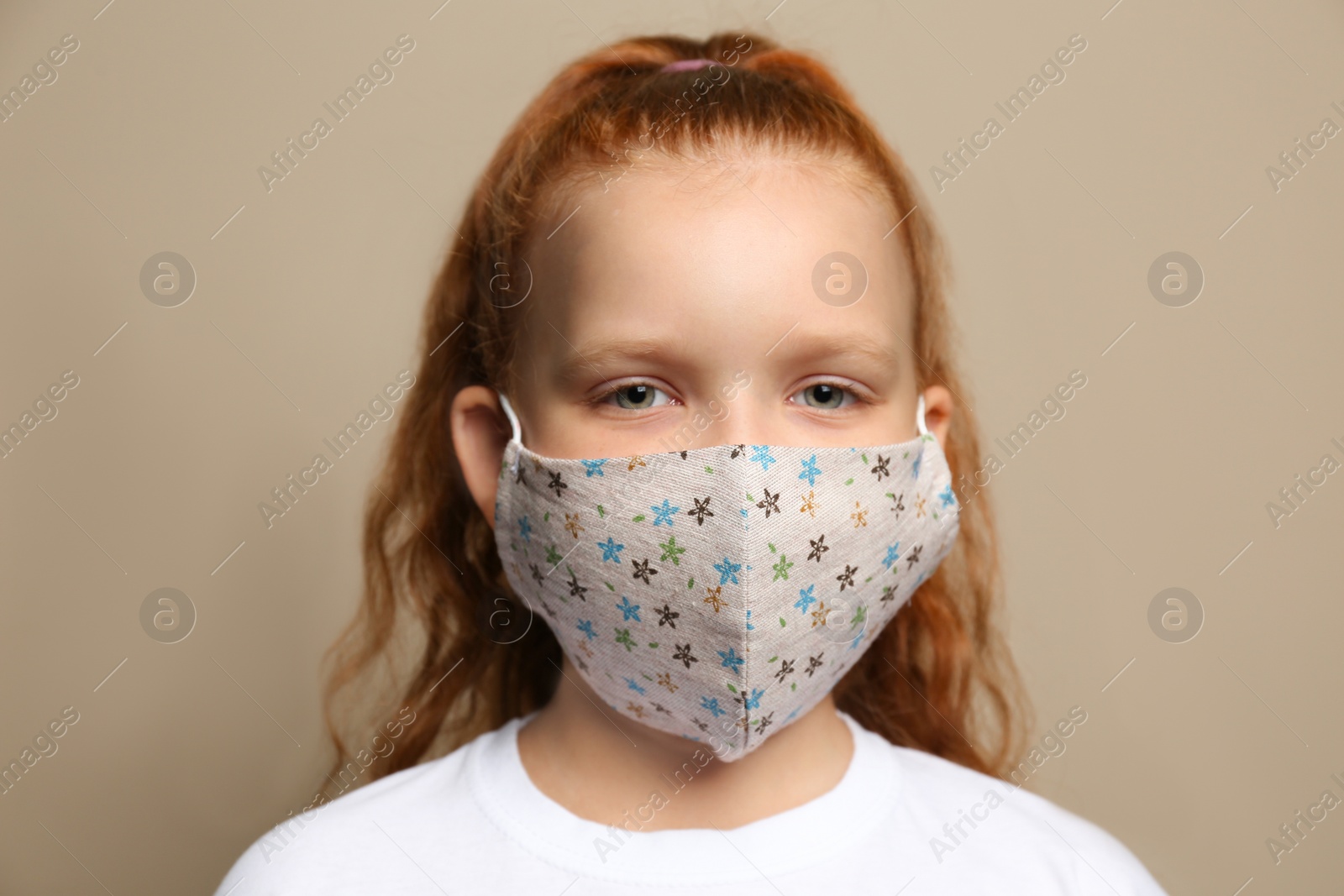 Photo of Preteen girl in protective face mask on brown background