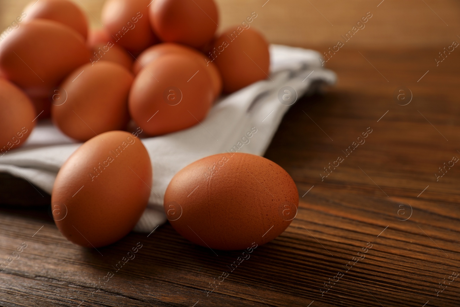 Photo of Raw brown chicken eggs on wooden table, closeup