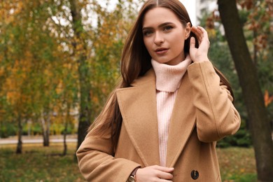 Beautiful young woman wearing stylish clothes in autumn park