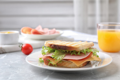 Photo of Tasty sandwich with ham on grey kitchen table. Space for text