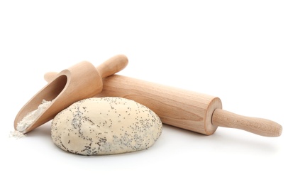 Photo of Raw dough with poppy seeds, rolling pin and scoop on white background