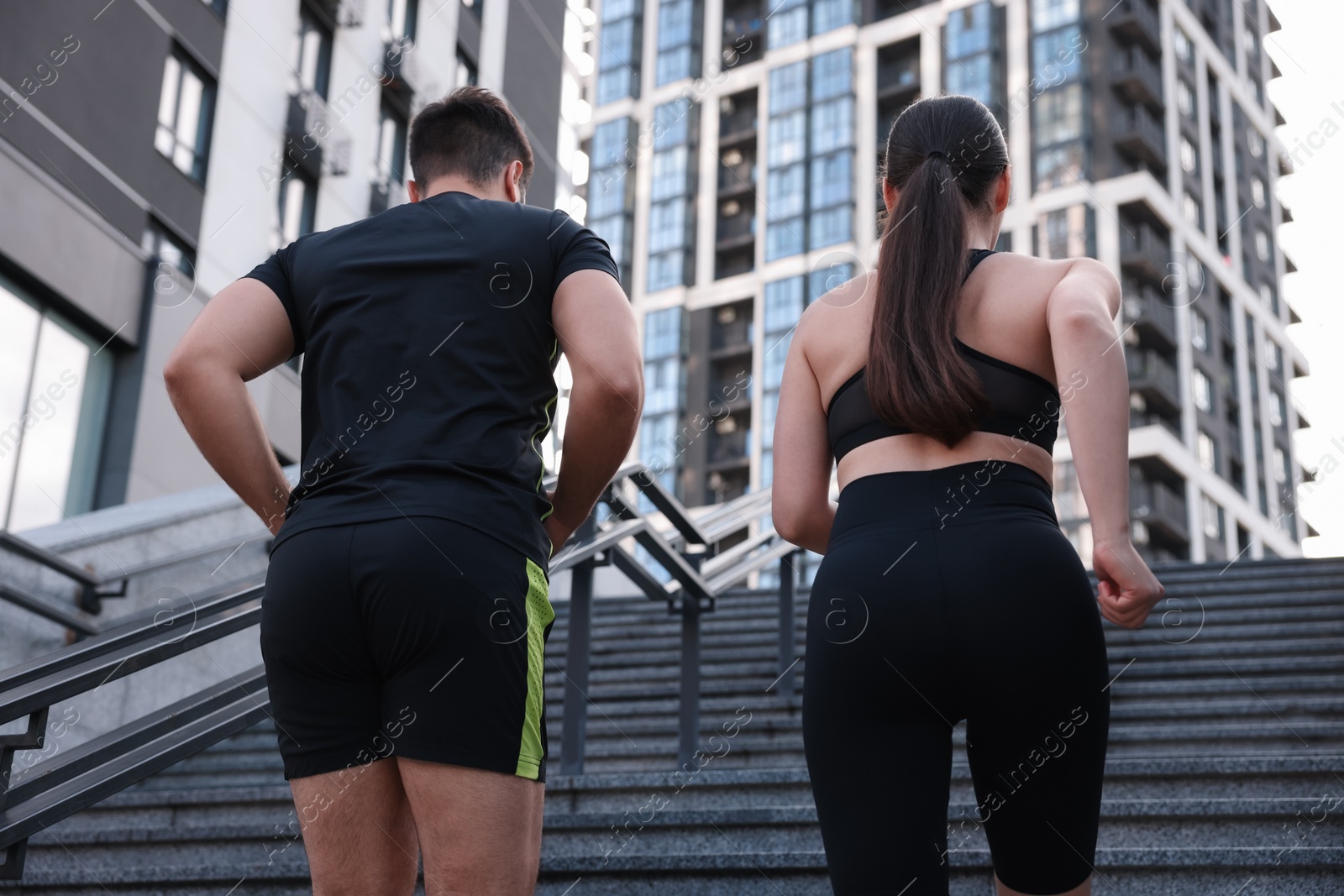 Photo of Healthy lifestyle. Couple running up steps outdoors, low angle view