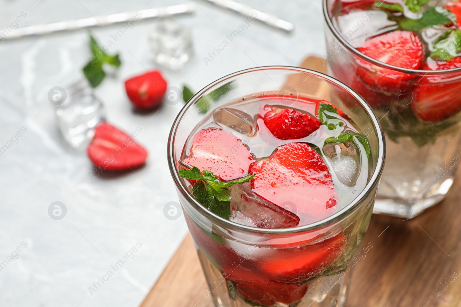 Photo of Glass of refreshing drink with strawberry and mint on table, closeup view. Space for text