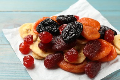 Photo of Mix of delicious dried fruits on light blue wooden table, closeup