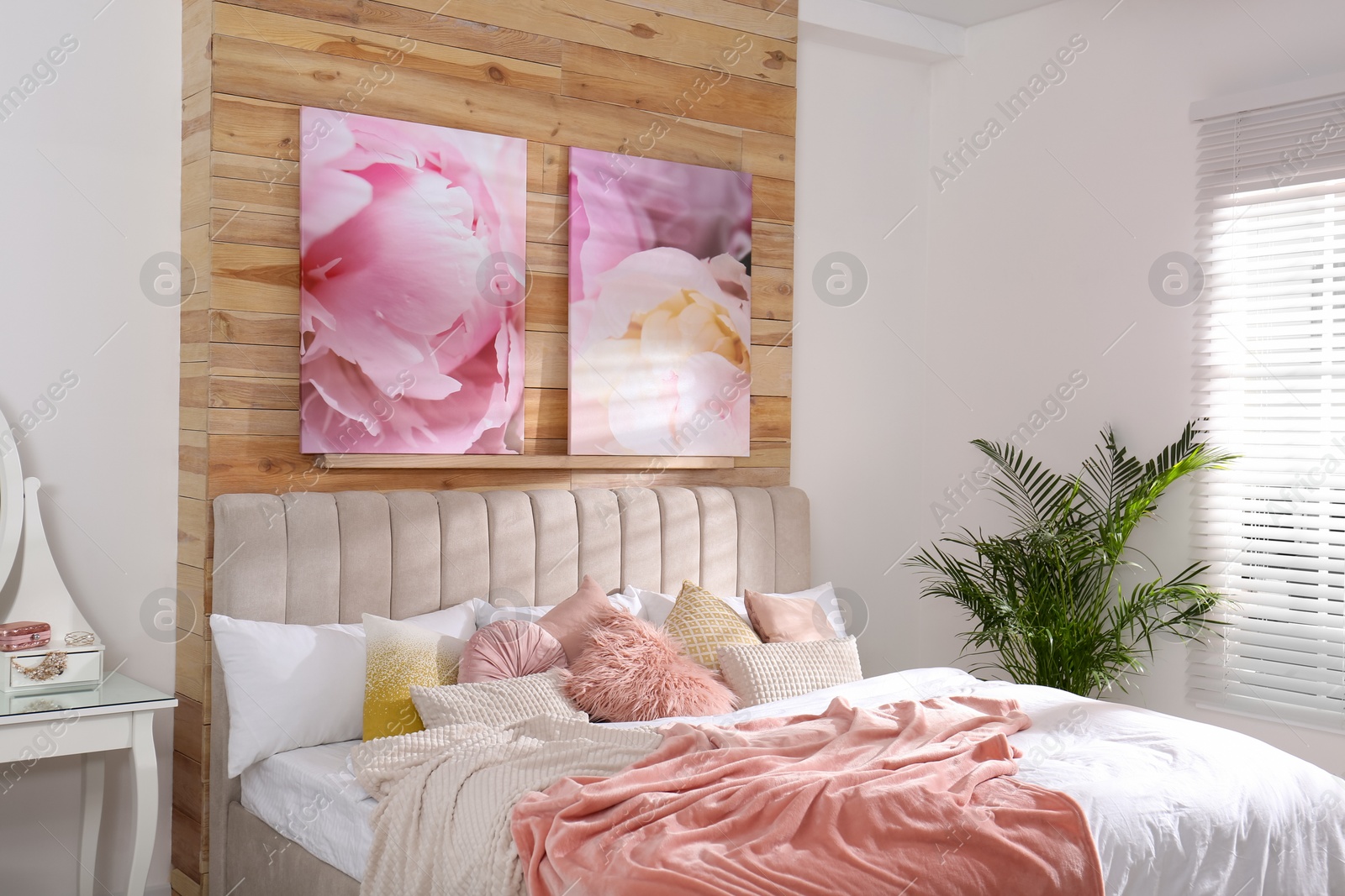 Photo of Stylish room interior with large comfortable bed and beautiful paintings