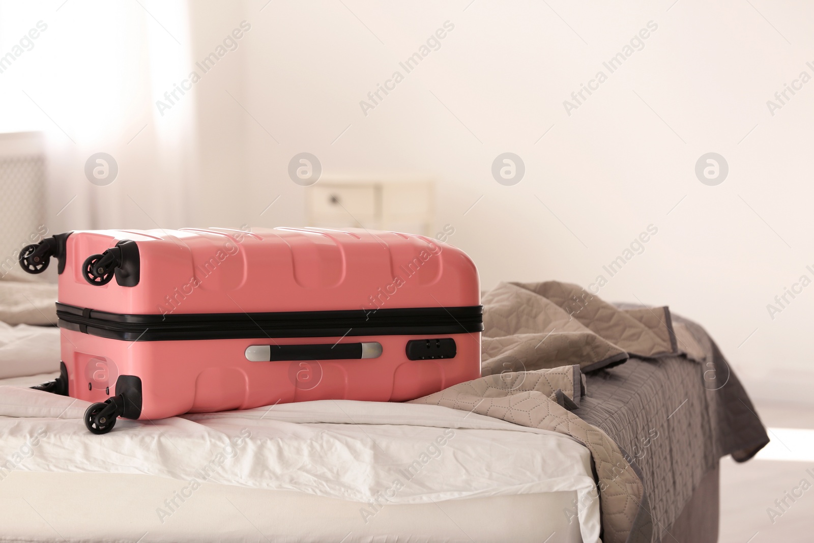 Photo of Color suitcase packed for journey on bed indoors