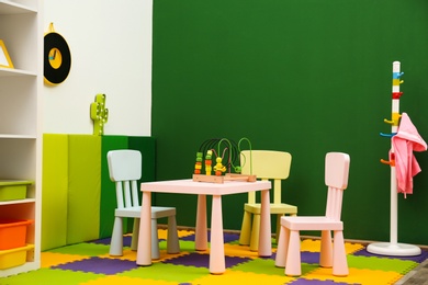 Stylish playroom interior with table and chairs