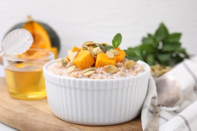 Tasty wheat porridge with pumpkin in bowl on table, closeup