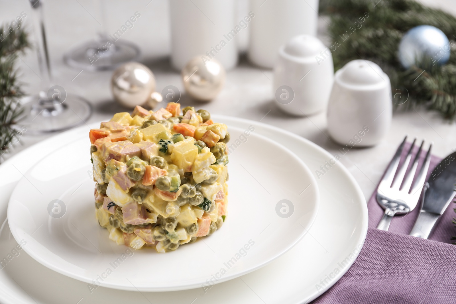 Photo of Traditional russian salad Olivier served on white table, space for text