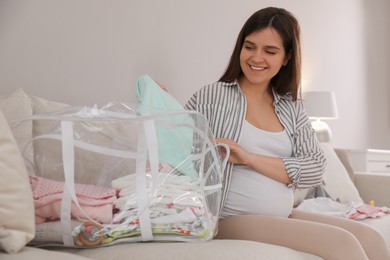 Pregnant woman packing bag for maternity hospital at home