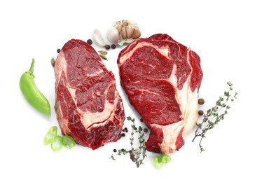 Photo of Pieces of beef meat with thyme and spices on white background, top view