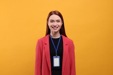 Photo of Smiling woman with vip pass badge on orange background