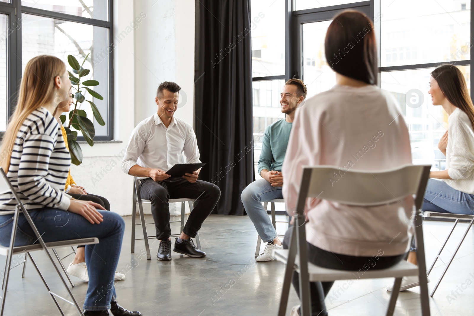 Photo of Psychotherapist working with patients in group therapy session indoors