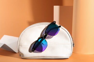 Image of New stylish elegant sunglasses with color lenses on orange background