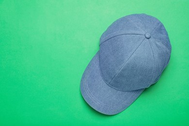 Baseball cap on green background, top view. Space for text