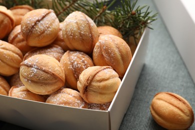 Photo of Box with delicious nut shaped cookies on table, closeup