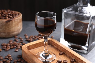 Coffee liqueur and beans on grey table