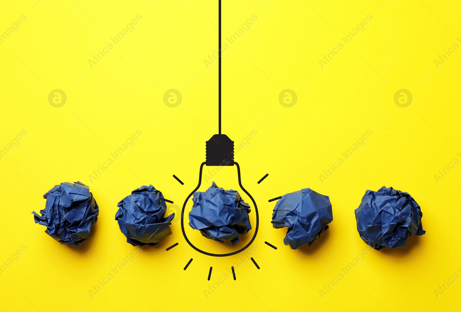 Image of Idea. Illustration of light bulb around crumpled paper ball on yellow background, flat lay