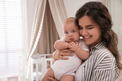 Happy young mother with her cute baby at home