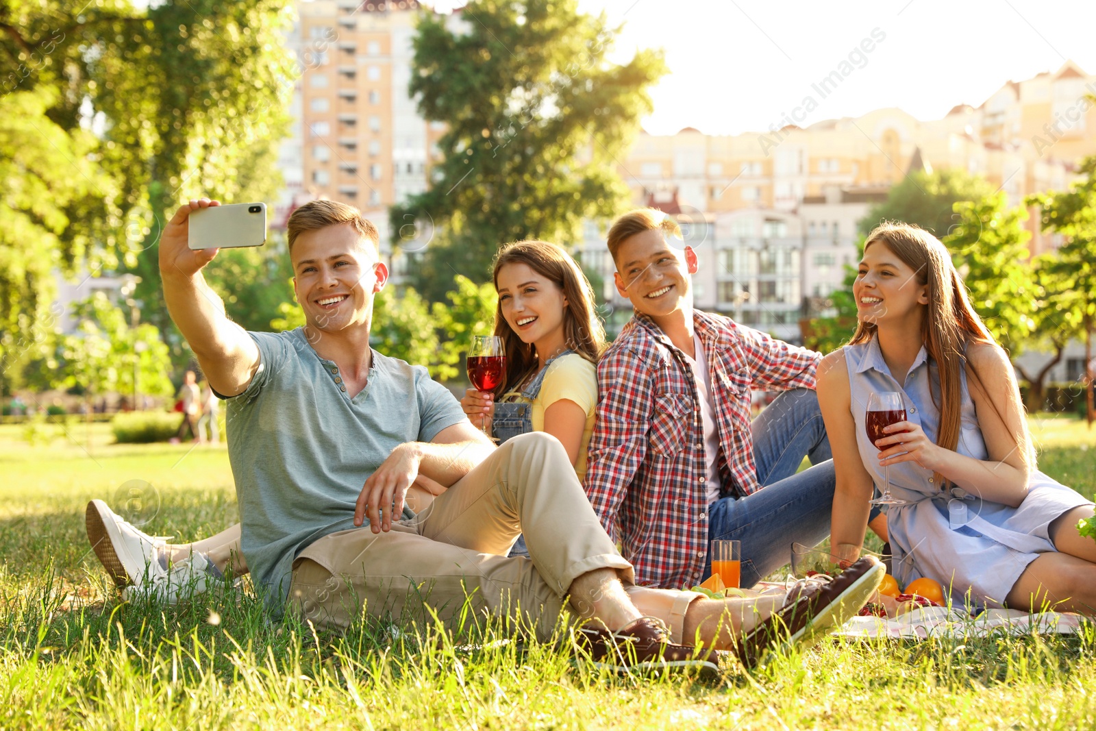 Photo of Young people enjoying picnic in park on summer day