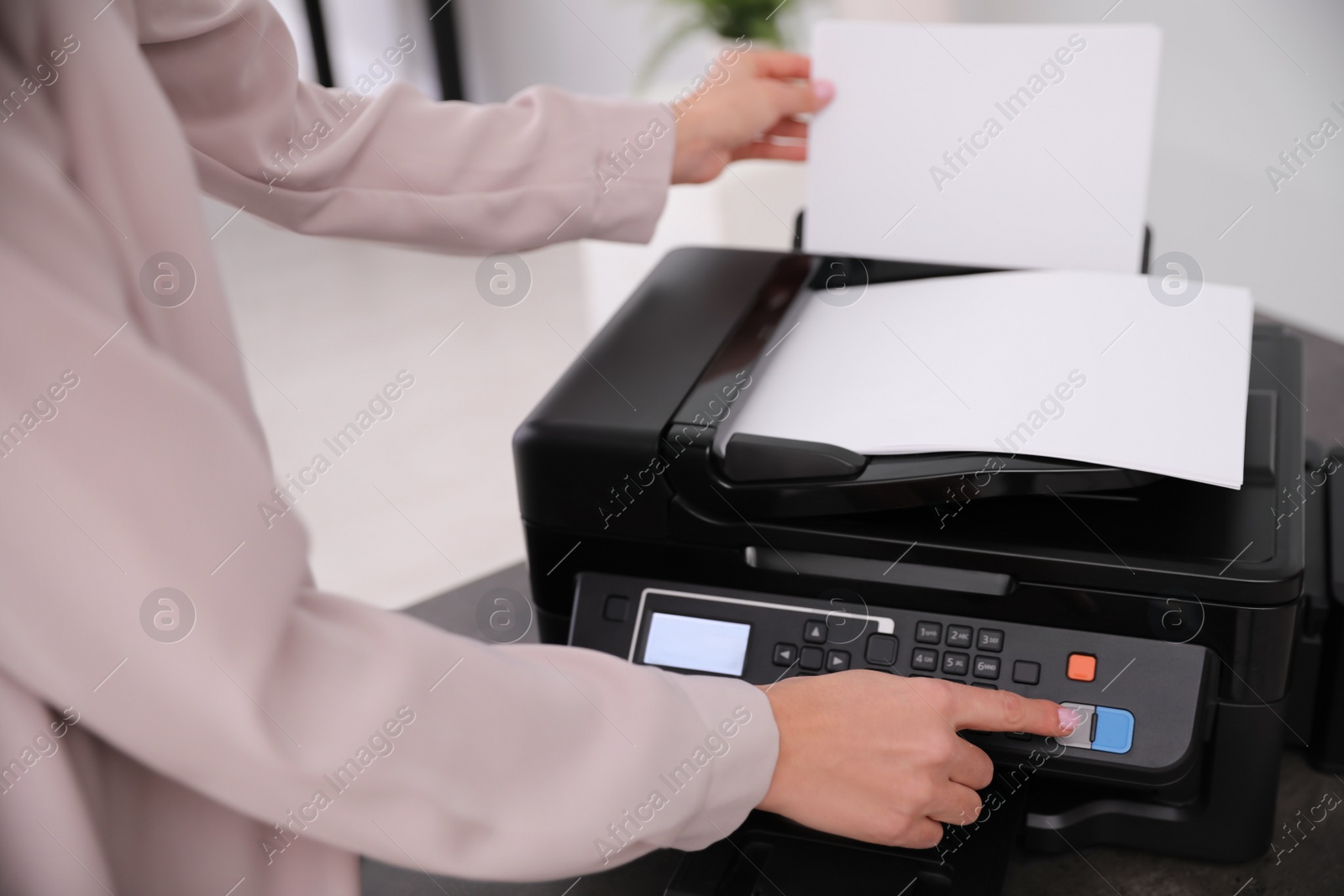 Photo of Employee using modern printer in office, closeup