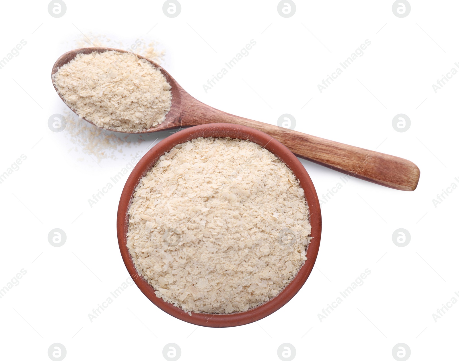Photo of Bowl and spoon with brewer's yeast flakes isolated on white, top view