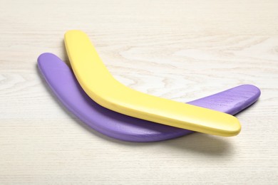 Photo of Color boomerangs on white wooden background. Outdoors activity