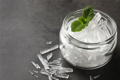 Menthol crystals and mint leaves on grey background, closeup. Space for text