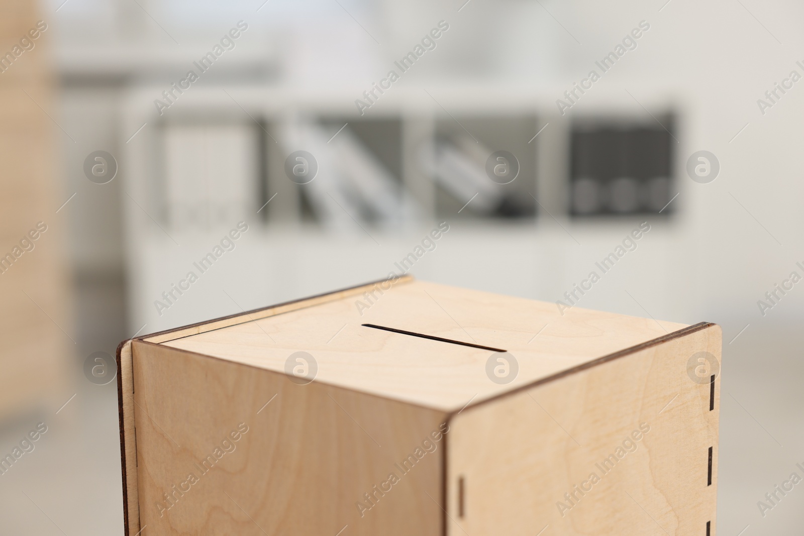 Photo of Wooden ballot box on blurred background, closeup. Space for text