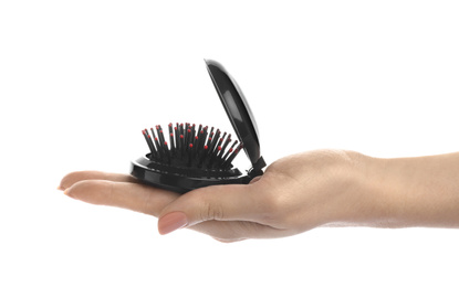 Woman holding round folding hair brush with mirror on white background, closeup