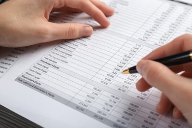 Photo of Woman working with accounting documents at table, closeup