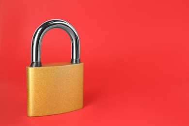 Photo of Modern padlock on red background. Space for text