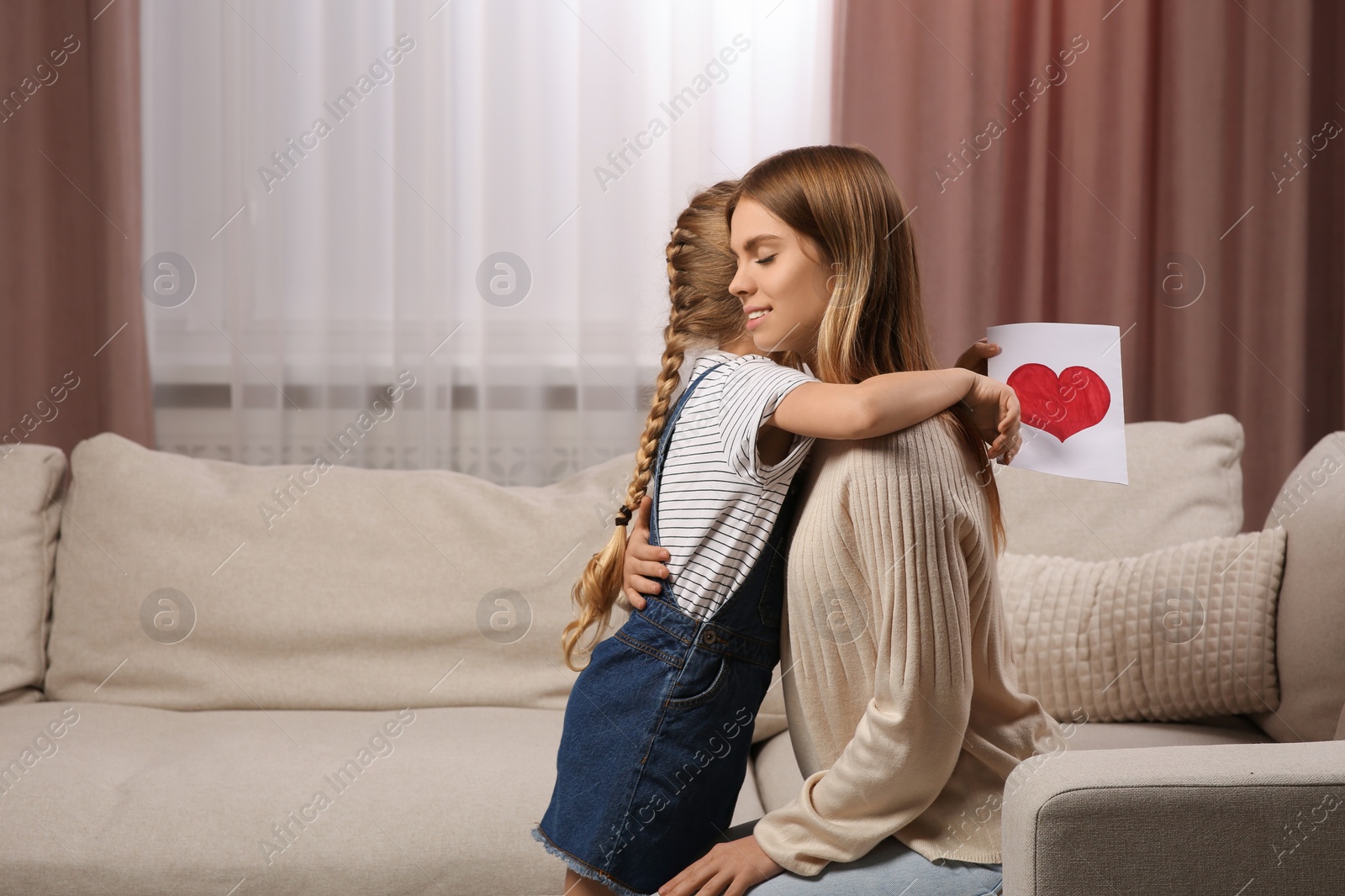 Photo of Little daughter congratulating her mom at home. Happy Mother's Day