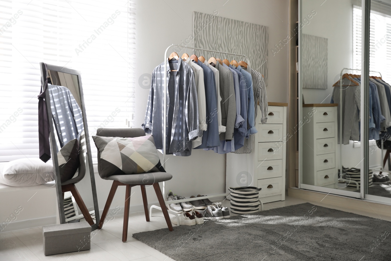 Photo of Dressing room interior with clothing rack and mirror