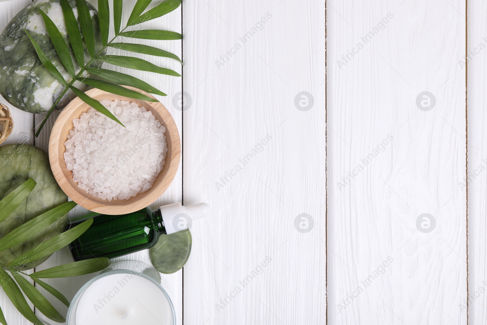 Photo of Flat lay composition with candle and different spa products on white wooden table. Space for text