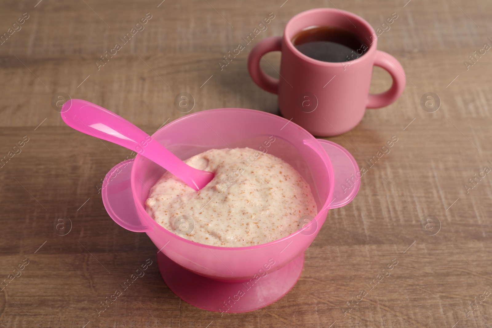 Photo of Baby food. Puree in bowl and drink on wooden table