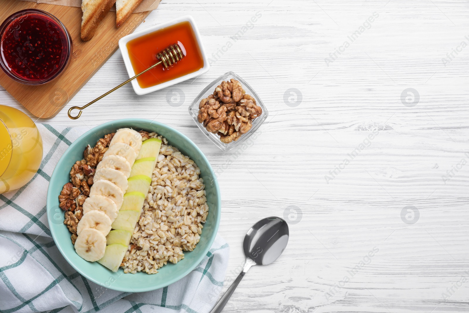 Photo of Tasty breakfast with oatmeal porridge on white wooden table, flat lay. Space for text