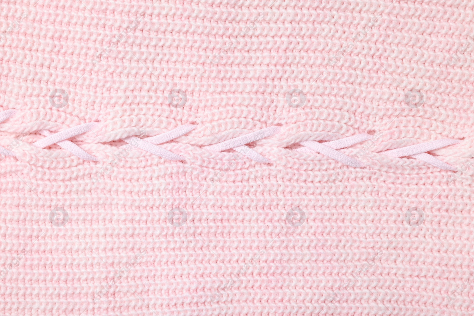 Photo of Texture of soft pink knitted fabric as background, top view