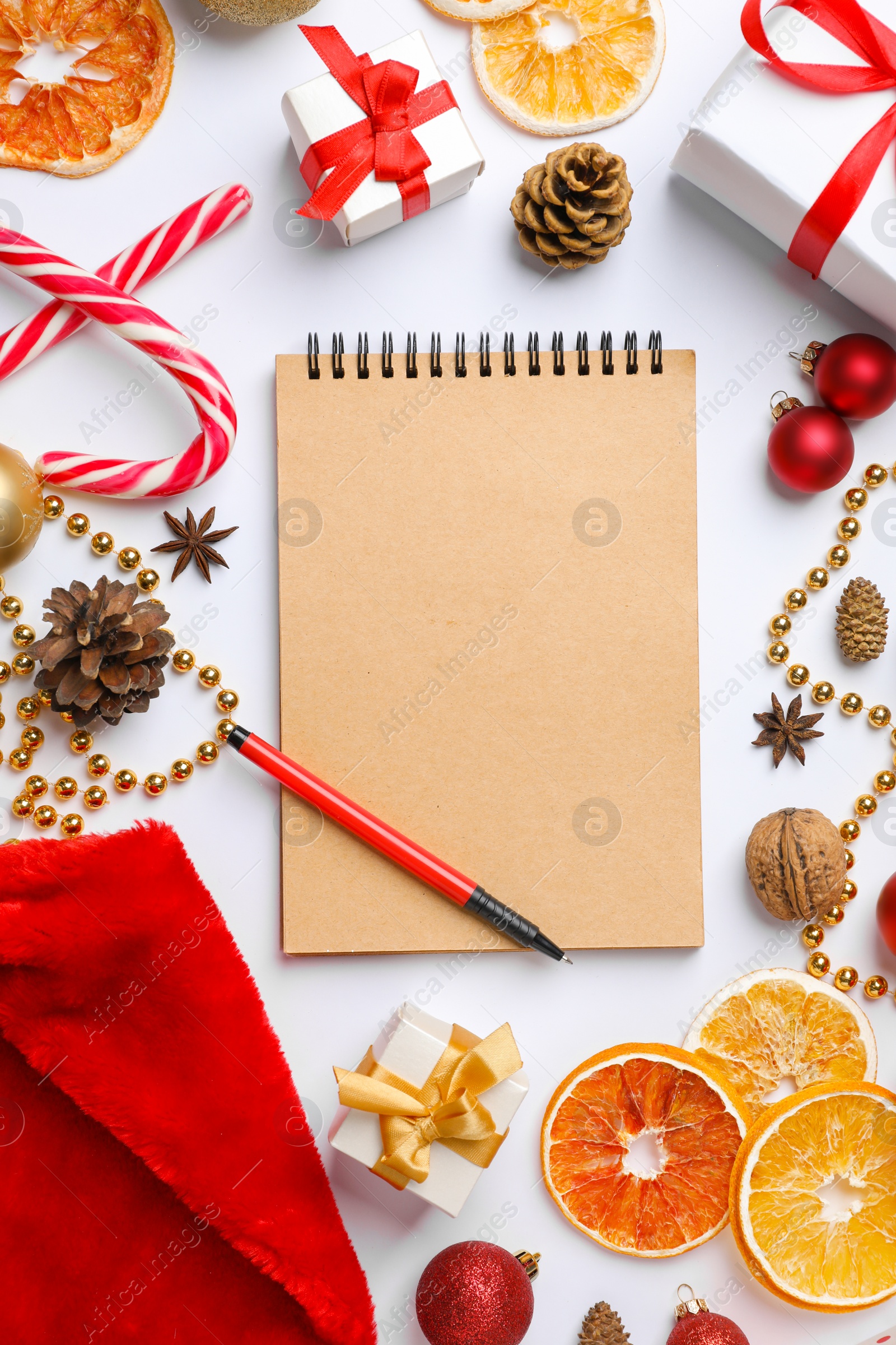 Photo of Flat lay composition with notebook and Christmas decor on white background. Letter for Santa Claus