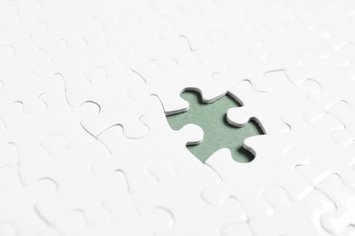 Blank white puzzle with missing piece on grey background